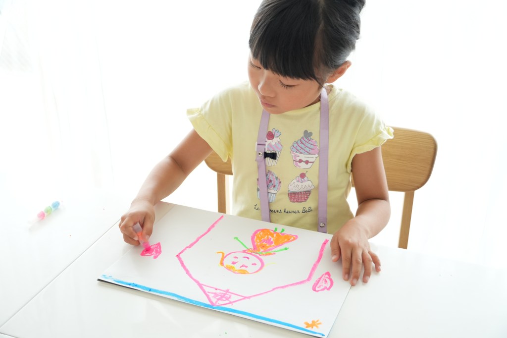 水で流せる、光るクレヨンで遊ぶ子ども